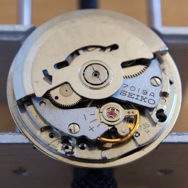 Thumbnail image of Seiko movement 7019A. The arrow in the rotor should be aligned with the hole in the reduction wheel for maximum winding efficiency.